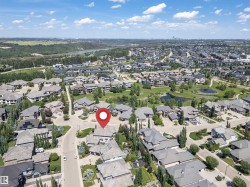 Aerial perspective of a residential community featuring diverse housing styles, mature trees, and a curvilinear street layout - 