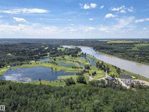 Expansive riverfront property featuring a golf course with multiple water hazards, mature tree lines, a significant river, and a dedicated parking area with a clubhouse structure - 3503 Watson Point(E), Edmonton, AB 