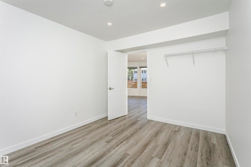 Bright interior space featuring wood-finish flooring, recessed lighting, and a neutral color palette - 17716 84 Avenue, Edmonton, AB 