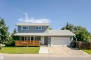 Two-story residence featuring a light gray exterior, a white front door, and a covered front porch with a wood slat railing - 17716 84 Avenue, Edmonton, AB 