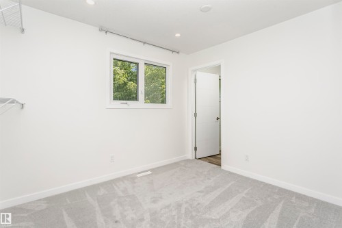 Light-filled room featuring a double window, recessed ceiling lighting, light grey patterned carpet, and minimalist white walls - 17716 84 Avenue, Edmonton, AB 