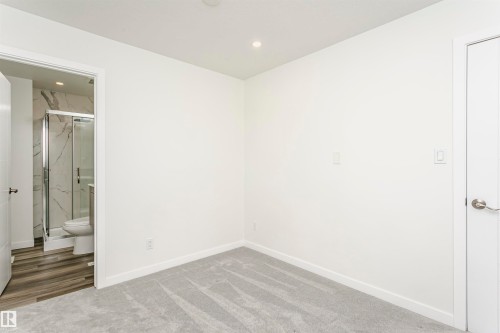 Carpeted room with recessed lighting and a white paneled door - 17716 84 Avenue, Edmonton, AB 