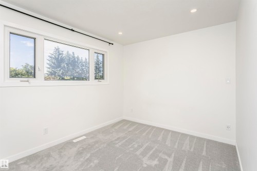 Bright room featuring a multi-pane window with white trim, recessed lighting, and light grey carpeting - 17716 84 Avenue, Edmonton, AB 