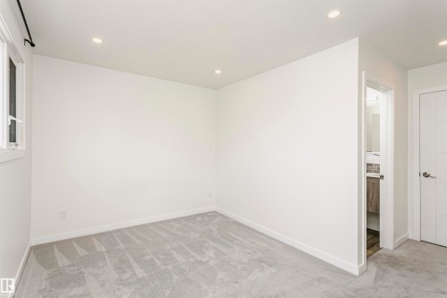 Bright room with recessed lighting, gray patterned carpeting, white trim, and white walls - 17716 84 Avenue, Edmonton, AB 