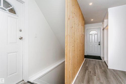 Entryway featuring a decorative wood-slat wall, recessed lighting, and wood-finish flooring - 17716 84 Avenue, Edmonton, AB 