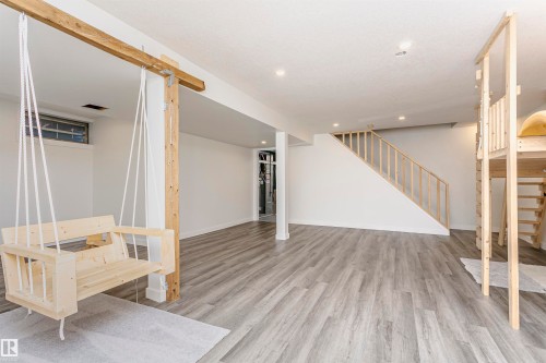 Spacious lower-level area featuring light wood-finish flooring and recessed ceiling lighting - 17716 84 Avenue, Edmonton, AB 