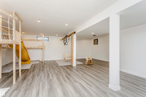 Spacious room featuring wood-finish flooring, recessed lighting, and white walls with white trim - 17716 84 Avenue, Edmonton, AB 