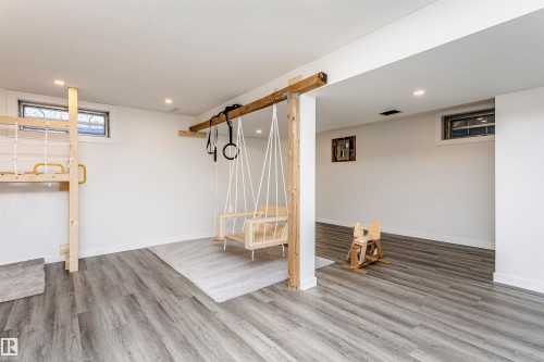 Spacious lower-level room featuring wood-finish flooring and recessed lighting - 17716 84 Avenue, Edmonton, AB 