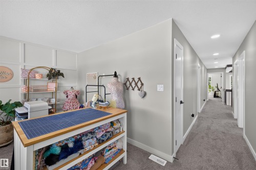 Bright interior space featuring a hallway with carpet flooring and recessed lighting - 1573 Esaiw Place, Edmonton, AB 