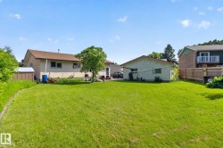 Expansive lawn area with a detached garage and a low-maintenance brick exterior residence - 