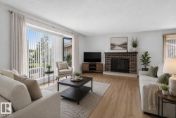 Spacious living area featuring light wood-finish flooring, a brick fireplace with a hearth, and a large picture window with vertical blinds - 