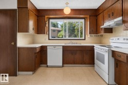 Kitchen featuring wood-finish cabinetry, white countertops, and light-toned tile flooring - 