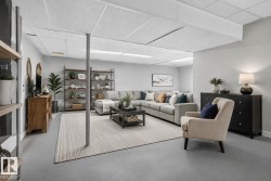 Finished lower level featuring a light gray color palette, recessed lighting, and drop ceiling - 