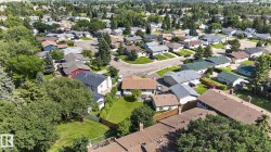 Residential neighborhood with mature trees, numerous single-family homes, and paved streets - 