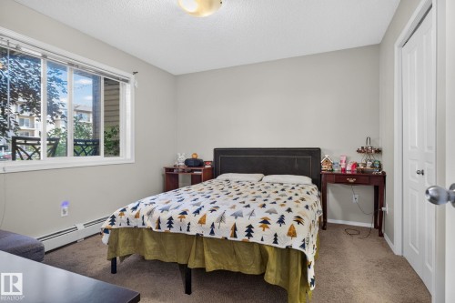 Bedroom featuring a large window, neutral wall paint, and carpet flooring - 140 301 Clareview Station Drive, Edmonton, AB 