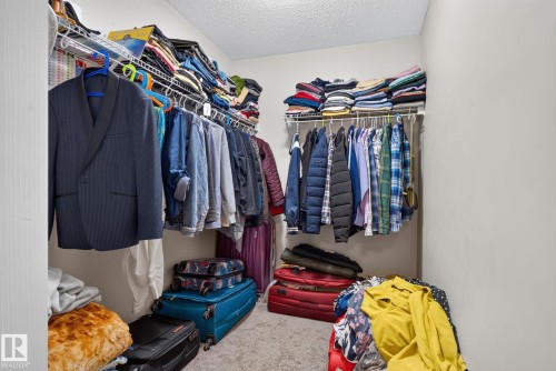 Walk-in closet featuring carpet flooring, neutral paint, and white wire shelving - 140 301 Clareview Station Drive, Edmonton, AB 