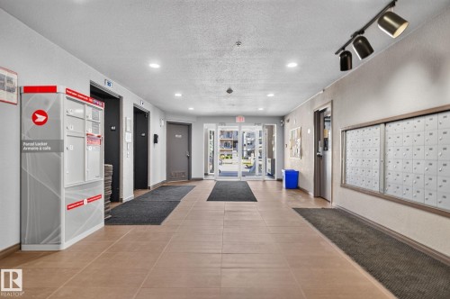 Building entryway featuring large format tile flooring and recessed lighting - 140 301 Clareview Station Drive, Edmonton, AB 