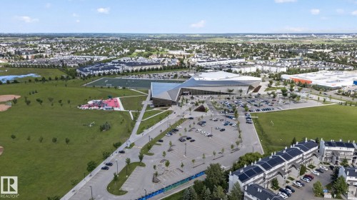 Aerial perspective showcasing a modern recreational facility with ample parking, extensive green spaces, and sports fields - 140 301 Clareview Station Drive, Edmonton, AB 