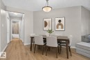 Dining area with wood-finish flooring, light grey wall paint, and a semi-flush mount ceiling light fixture - 140 301 Clareview Station Drive, Edmonton, AB 