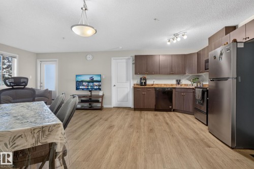 Open-concept living space featuring wood-finish flooring throughout - 140 301 Clareview Station Drive, Edmonton, AB 