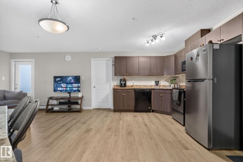 Open-concept living space featuring wood-finish flooring - 140 301 Clareview Station Drive, Edmonton, AB 