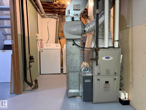 Utility area featuring a modern Carrier furnace, an Affinion humidifier, and exposed ductwork - 166 Roseland Village, Edmonton, AB - Indoor Photo Showing Basement