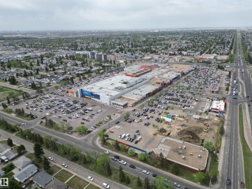 Expansive commercial property featuring a large retail complex, multiple surface parking lots, surrounding residential areas, and prominent arterial roadways - 166 Roseland Village, Edmonton, AB - Outdoor With View