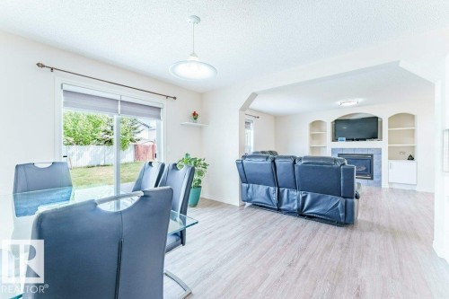Open-concept living space featuring wood-finish flooring and an arched entryway - 3525 22 Street, Edmonton, AB - Indoor With Fireplace