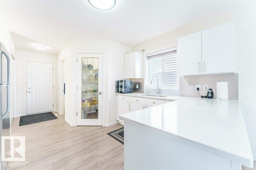 Modern kitchen featuring light wood-finish flooring and white cabinetry - 3525 22 Street, Edmonton, AB - Indoor Photo Showing Kitchen