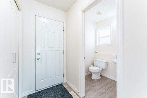 Entryway featuring light wood-finish flooring and a white paneled door - 3525 22 Street, Edmonton, AB - Indoor Photo Showing Bathroom