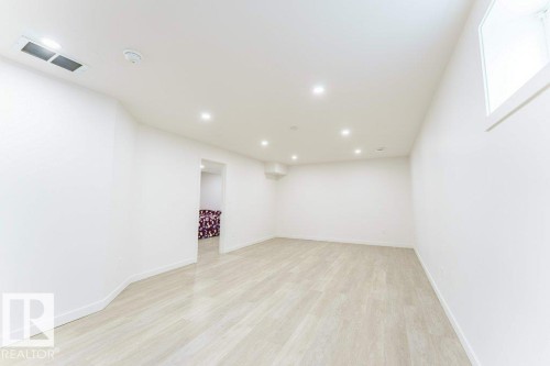 Spacious room featuring light wood-finish flooring, recessed lighting, and a white color palette - 3525 22 Street, Edmonton, AB - Indoor Photo Showing Other Room