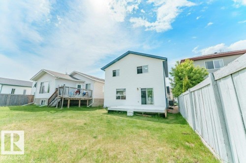Spacious rear yard featuring a white painted privacy fence, a wooden deck, and a sliding glass door for outdoor access - 3525 22 Street, Edmonton, AB - Outdoor With Deck Patio Veranda With Exterior
