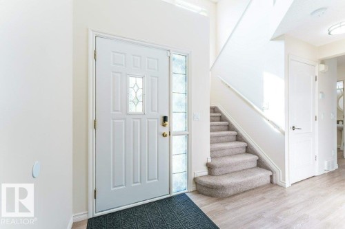 Entryway featuring a panel door with decorative glass insert, a full-length sidelight, and wood-finish flooring - 3525 22 Street, Edmonton, AB - Indoor Photo Showing Other Room