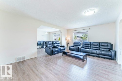 Spacious living area featuring light wood-finish flooring, white walls, and a recessed ceiling light fixture - 3525 22 Street, Edmonton, AB - Indoor Photo Showing Living Room