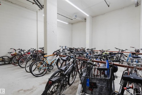 Dedicated bike storage area featuring multiple racks and overhead strip lighting - 608 10303 105 Street, Edmonton, AB 