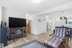 Open-concept living area featuring light wood-finish flooring throughout - 