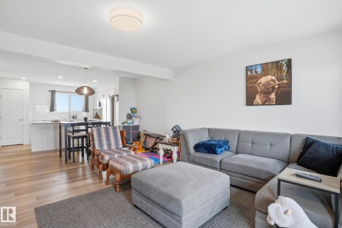 Open-concept living area featuring wood-finish flooring, white walls, and a recessed ceiling light - 58 Jensen Gate, St. Albert, AB 