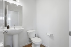 Contemporary pedestal sink with a chrome faucet, illuminated by a modern vanity light fixture - 