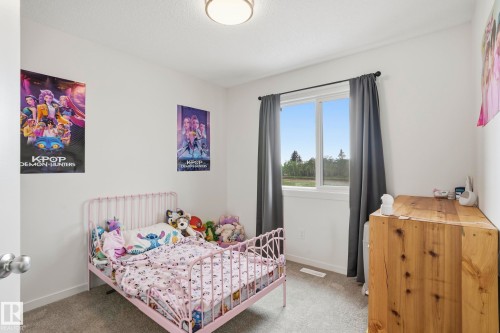 White walls and gray carpeting, featuring a window with dark gray drapes - 58 Jensen Gate, St. Albert, AB 