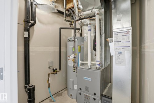 Utility area with water heater, furnace, and exposed plumbing - 58 Jensen Gate, St. Albert, AB 