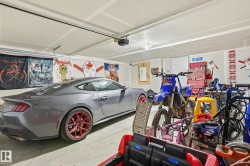 Attached garage featuring a concrete floor, painted drywall, and overhead lighting - 