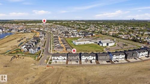 Aerial perspective of a developing residential community featuring a variety of housing types, including row houses and detached homes - 58 Jensen Gate, St. Albert, AB 