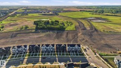 New construction residential development featuring a row of multi-story homes with contrasting dark and light facades - 