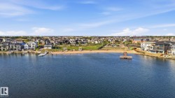Expansive waterfront community featuring a private sandy beach, multiple docks, residential properties, and clear blue water - 