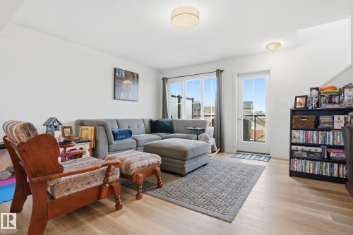 Bright living space featuring light wood-finish flooring and white walls - 58 Jensen Gate, St. Albert, AB 