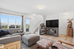 Bright living space featuring a large window wall with multiple panes and a glass-paneled door - 