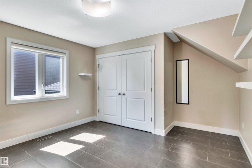 Room featuring durable tile flooring, a double-door closet, and a window with white trim - 9 Shorewood Crescent, Leduc, AB - Indoor Photo Showing Other Room
