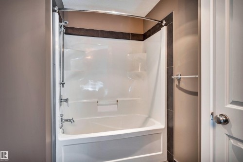 Bathtub/shower combination featuring integrated shelving and chrome fixtures - 9 Shorewood Crescent, Leduc, AB - Indoor Photo Showing Bathroom
