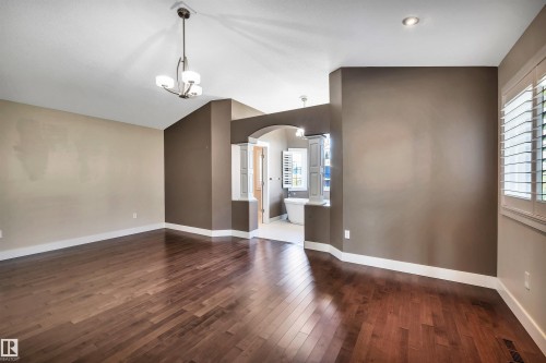 Expansive room featuring wood-finish flooring, vaulted ceilings, and a contemporary chandelier - 9 Shorewood Crescent, Leduc, AB - Indoor Photo Showing Other Room
