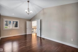 Vaulted ceiling featuring a contemporary chandelier and recessed lighting - 